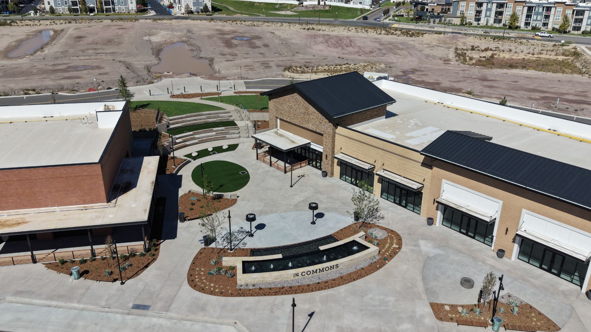 Aerial view of the central plaza at The Commons, with the amphitheater lawn, putting green and The Commons water feature