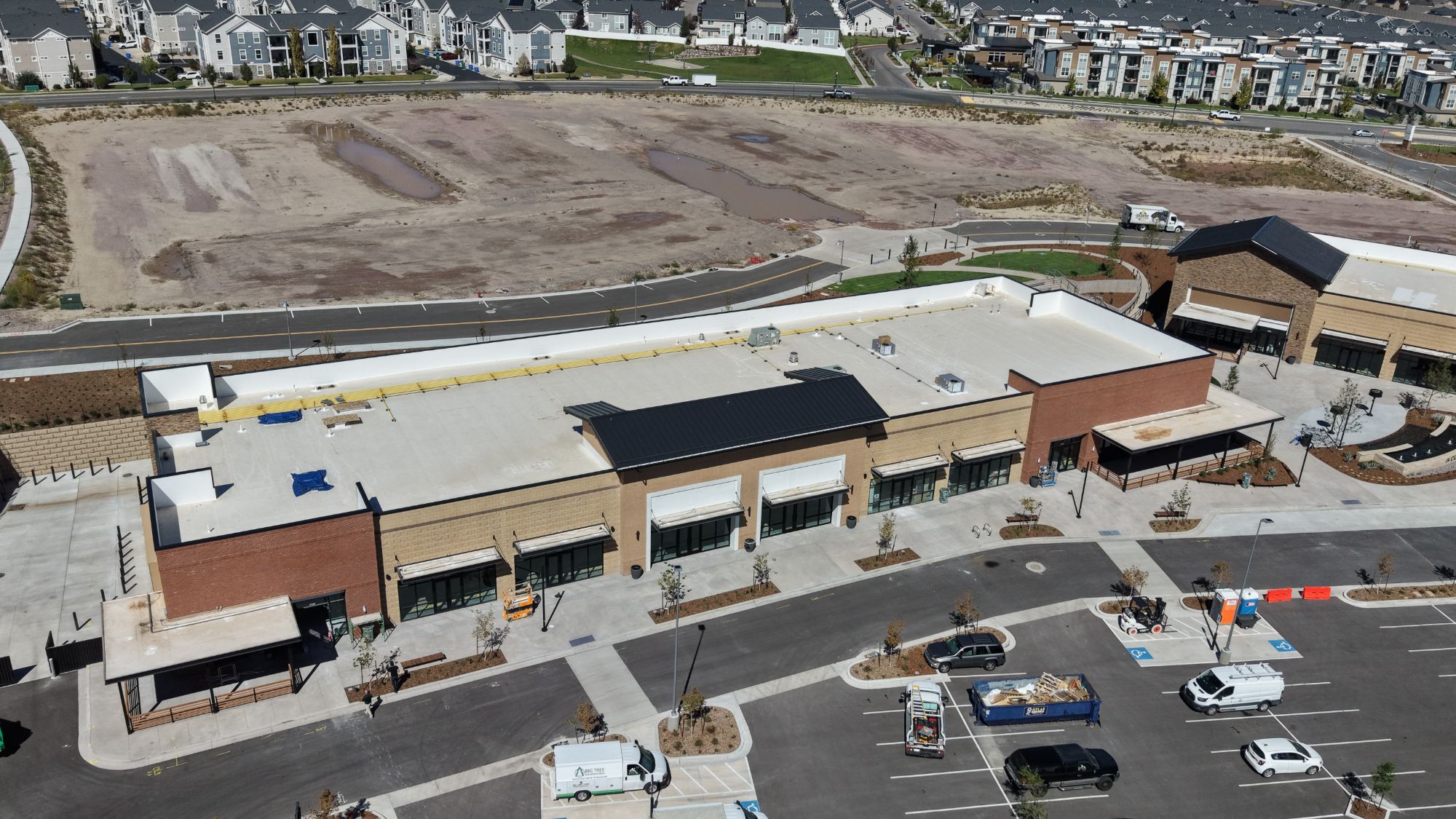 Aerial view of the long retail building and parking at The Commons